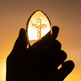 Glaskreuz Jesus in der Hand